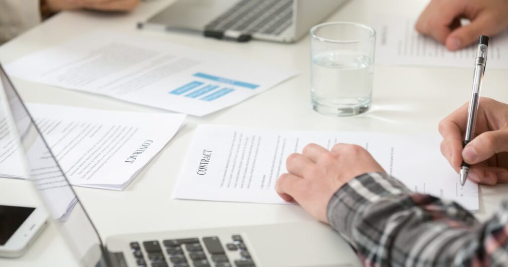 HR documents for startups shown by a businessman signing a contract