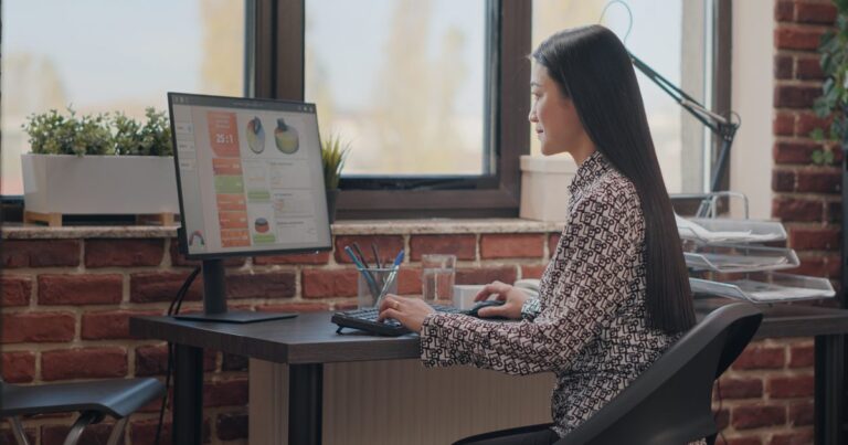 HRMS for small business shown by a woman working on a computer in an office